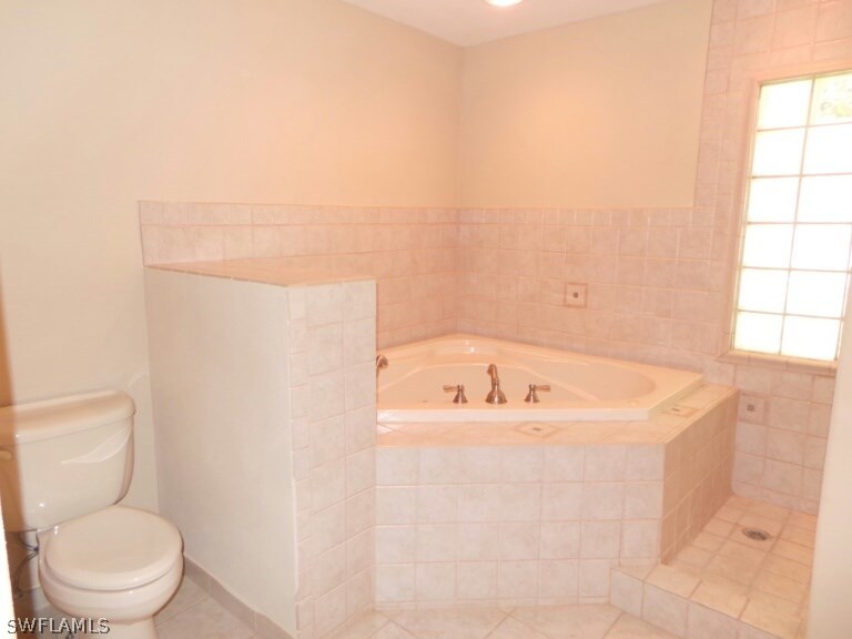 17448 Lee Road Fort Myers, FL 33967 - Photo 12 of 20 a bath tub sitting next to a white toilet