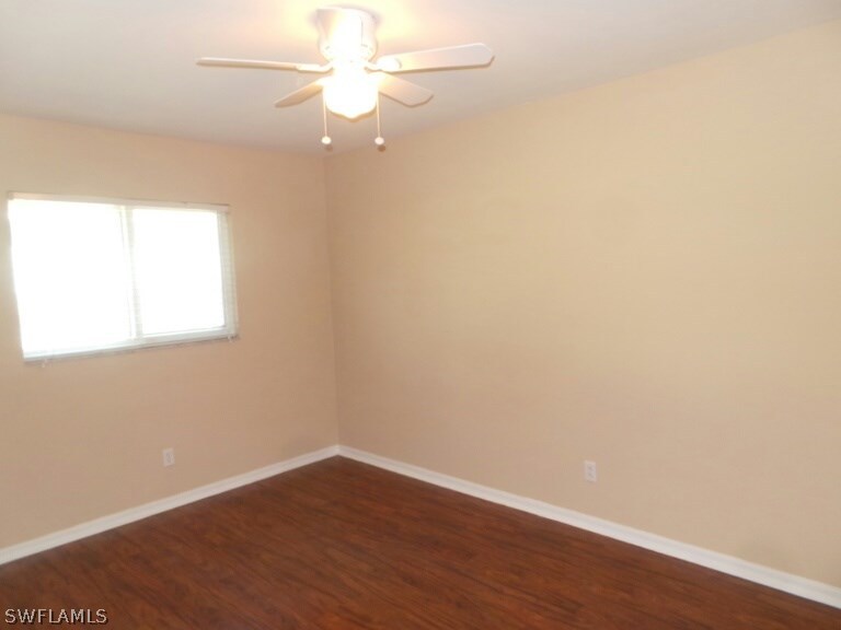 17448 Lee Road Fort Myers, FL 33967 - Photo 15 of 20 an empty room with wooden floor and fan