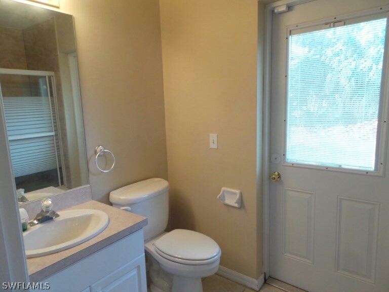 17448 Lee Road Fort Myers, FL 33967 - Photo 16 of 20 a bathroom with a granite countertop toilet a sink and a mirror