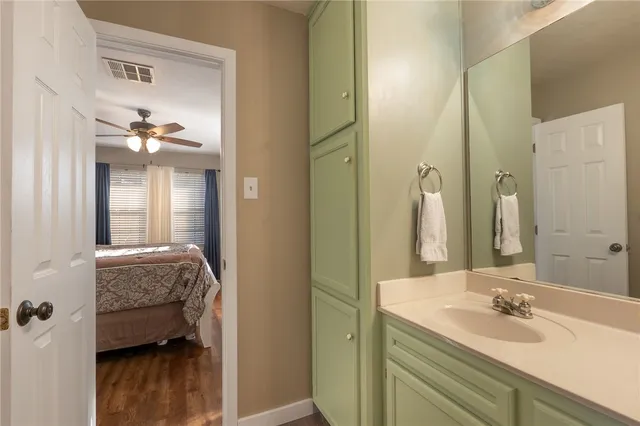 a en suite bathroom with a granite countertop sink and a mirror