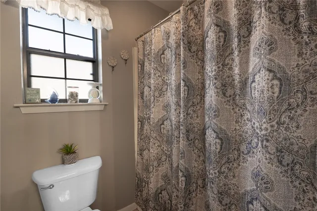 a white toilet sitting next to a window