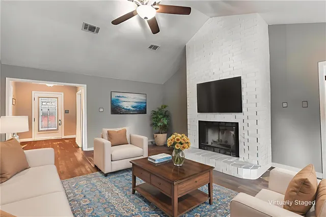 a living room with furniture a flat screen tv and a fireplace