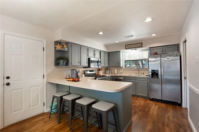a kitchen with refrigerator and chairs