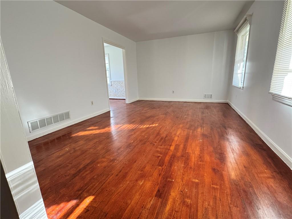 5297 Cardinal Lane Northwest Lilburn, GA 30047 - Photo 17 of 31 an empty room with wooden floor and windows