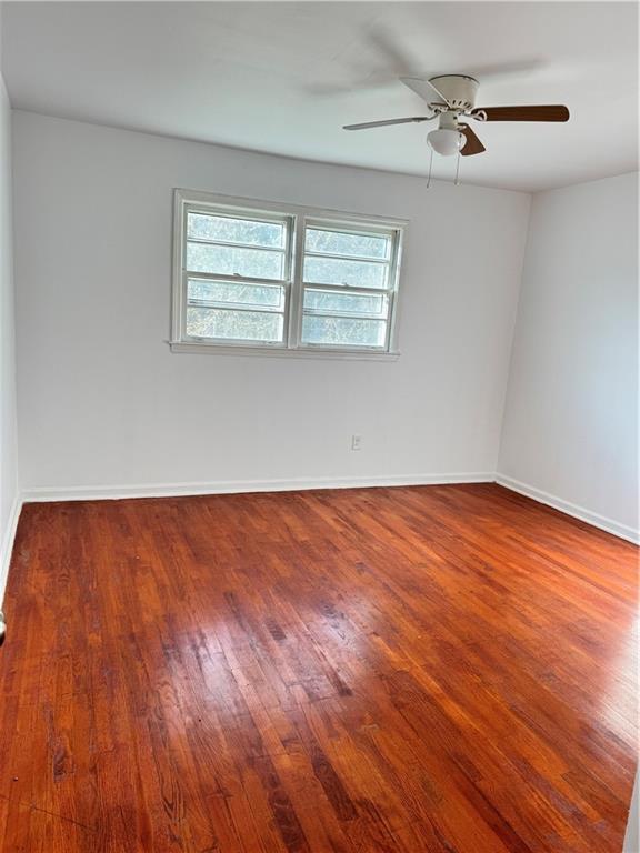 5297 Cardinal Lane Northwest Lilburn, GA 30047 - Photo 19 of 31 a view of empty room with wooden floor and fan