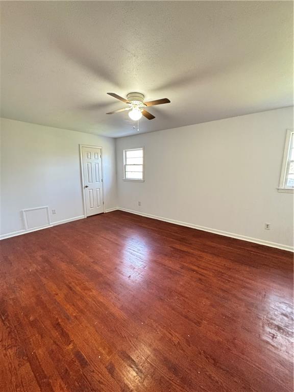 5297 Cardinal Lane Northwest Lilburn, GA 30047 - Photo 21 of 31 an empty room with wooden floor and windows