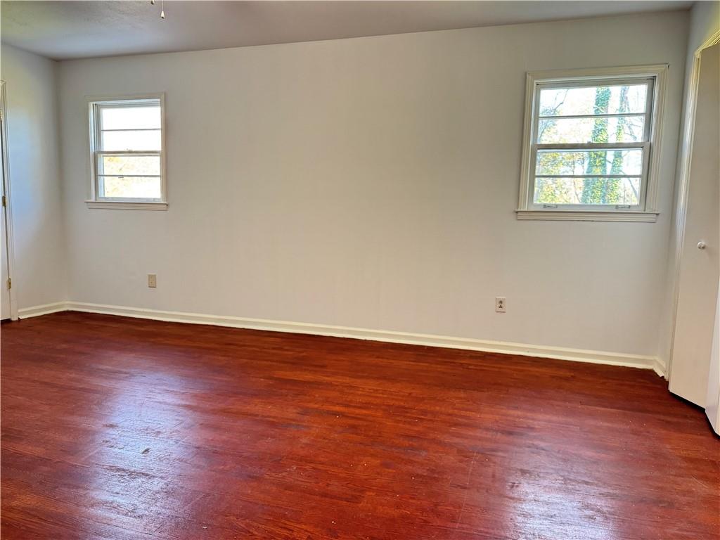 5297 Cardinal Lane Northwest Lilburn, GA 30047 - Photo 24 of 31 an empty room with wooden floor and windows