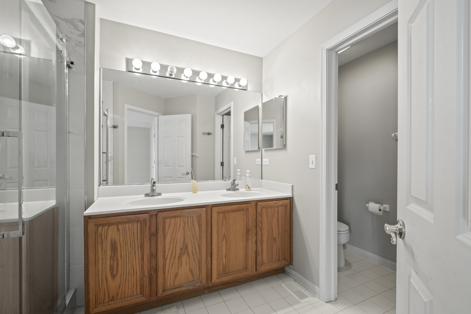 7917 Windsor Drive Darien, IL 60561 - Photo 14 of 31 a bathroom with a double vanity sink and a mirror