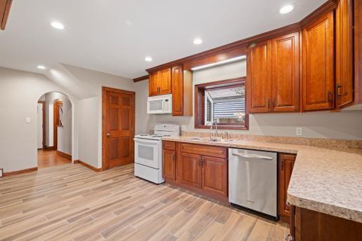 1611 Roemer Boulevard Farrell, PA 16121 - Photo 12 of 35 a kitchen with stainless steel appliances granite countertop a refrigerator a sink dishwasher and wooden cabinets with wooden floor