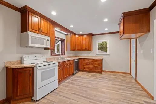a kitchen with granite countertop a sink window and cabinets