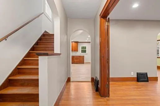 a view of a hallway with wooden floor and staircase