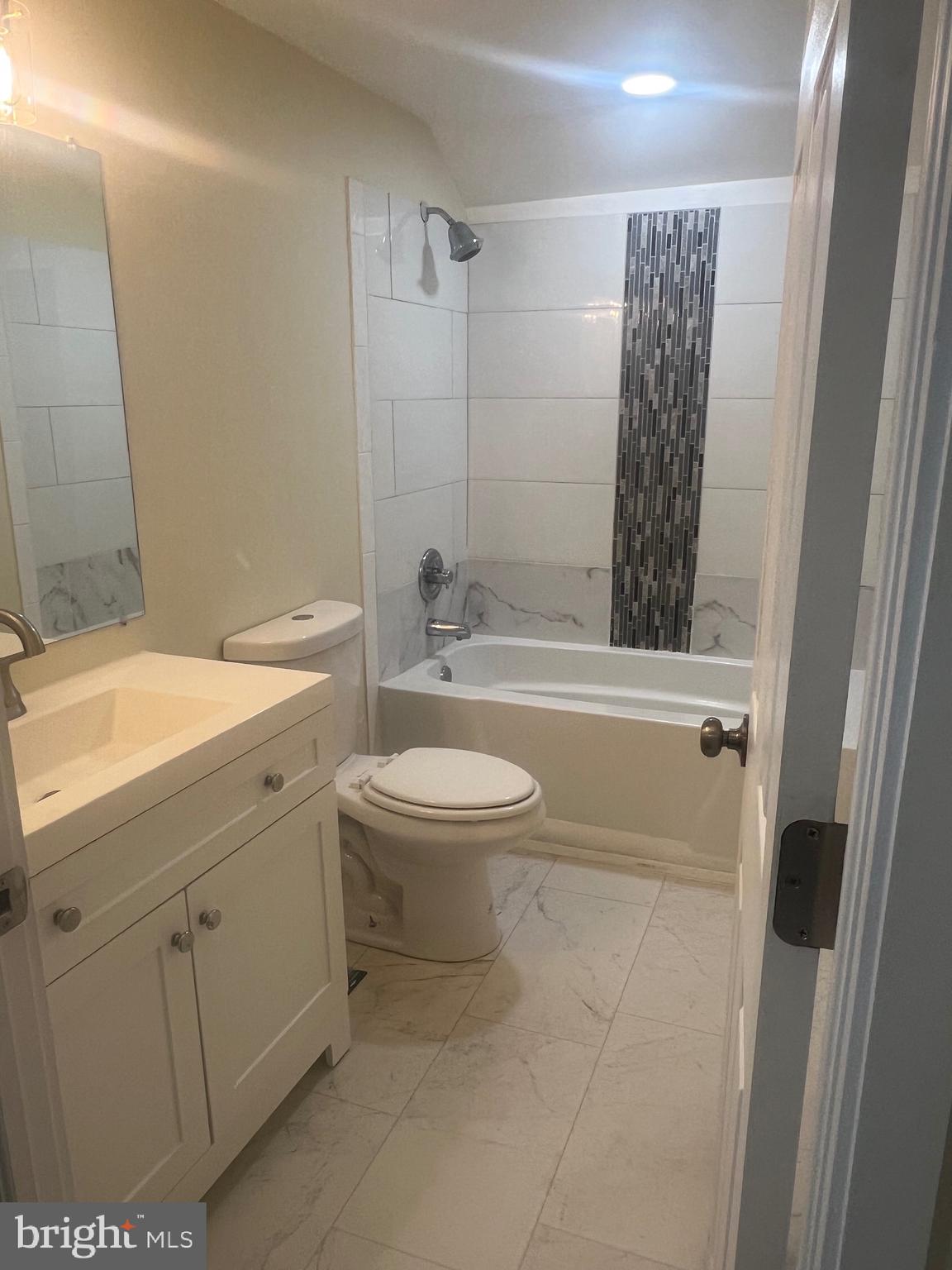 5732 Bugler Street Capitol Heights, MD 20743 - Photo 19 of 23 a bathroom with a toilet a sink a mirror a bathtub and shower