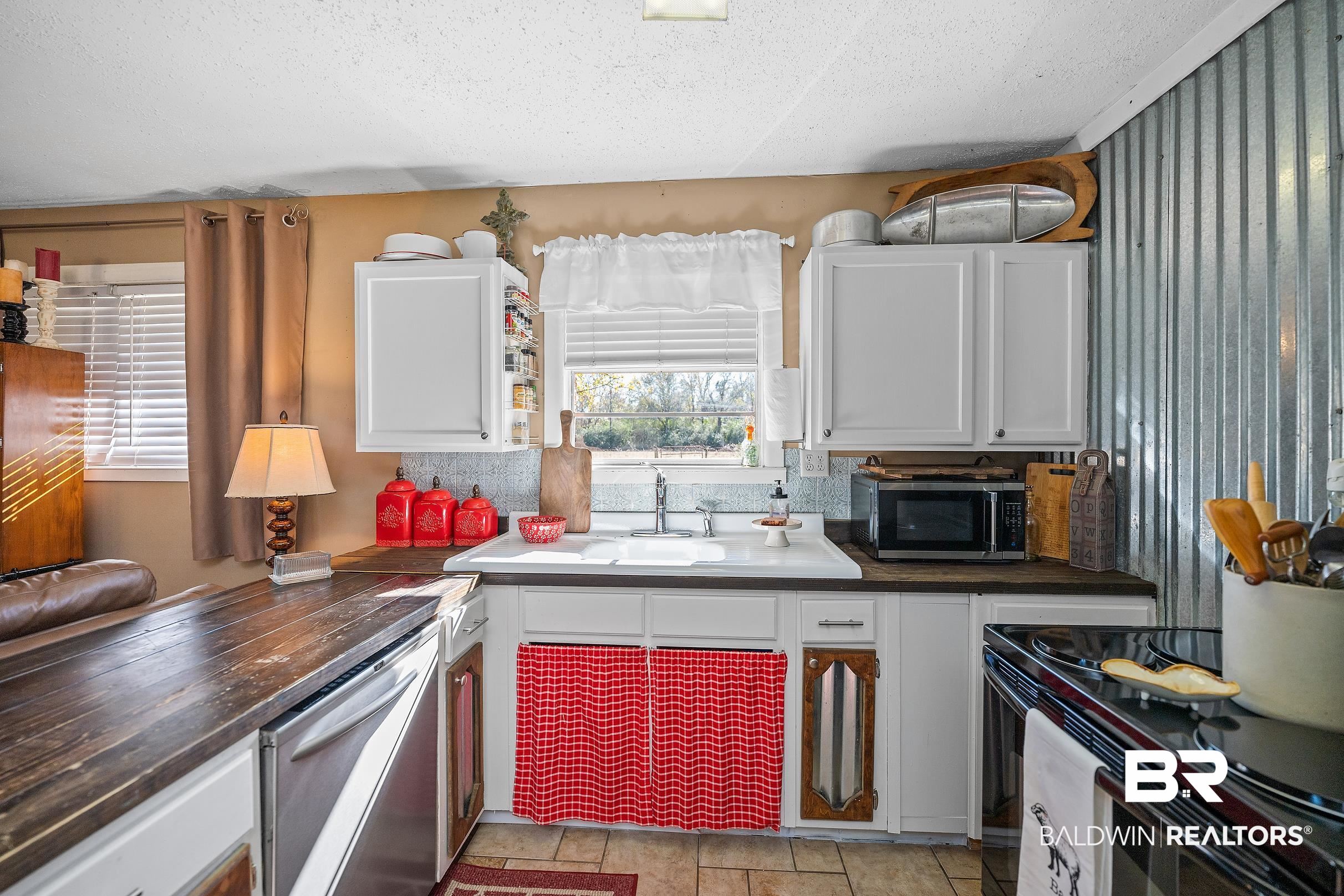 110 Sam Jones Road Atmore, AL 36502 - Photo 19 of 47 Kitchen with dark countertops, white cabinetry, appliances with stainless steel finishes, and a textured ceiling