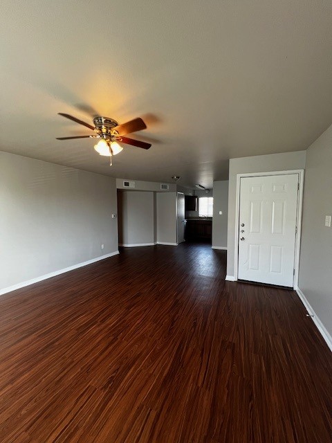 1172 Webberville Road Austin, TX 78721 - Photo 2 of 9 Unfurnished living room with dark wood-type flooring and a ceiling fan