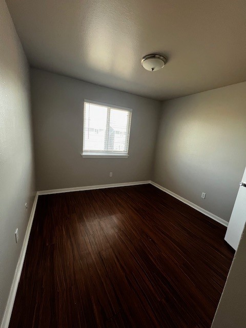 1172 Webberville Road Austin, TX 78721 - Photo 5 of 9 Spare room with dark wood-type flooring and a textured ceiling
