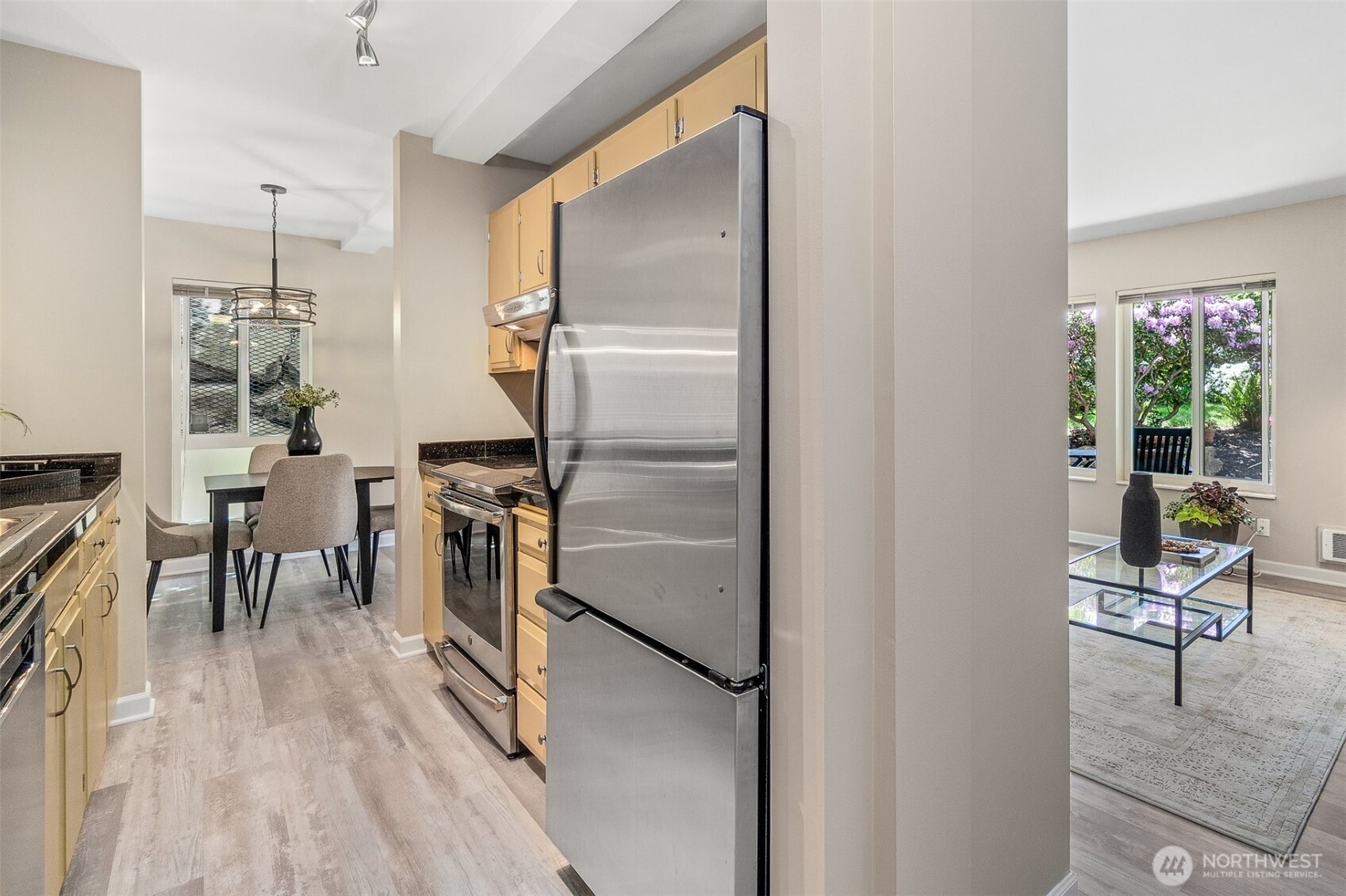75 East Lynn Street, Unit B Seattle, WA 98102 - Photo 12 of 36 a kitchen with stainless steel appliances granite countertop a refrigerator a stove and a dining table with wooden floor