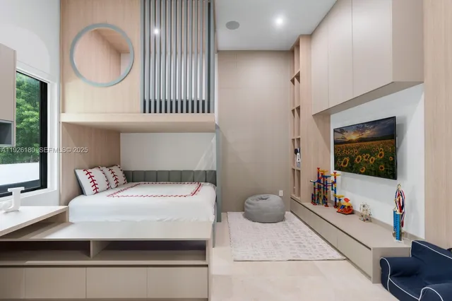 a bedroom with a bed and a flat tv screen on the dresser