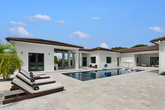 a view of pool with lawn chairs and wooden fence