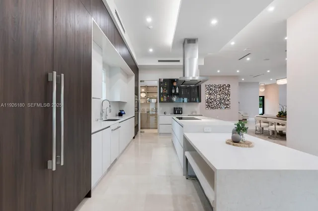 a large white kitchen with a large counter top appliances and cabinets