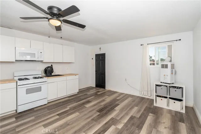 a kitchen with a stove a sink and white cabinets