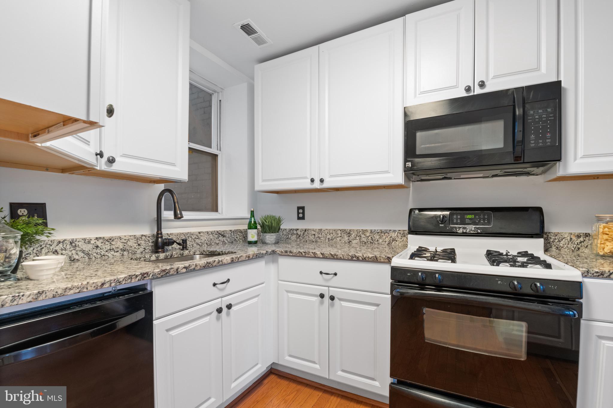 36 Q Street Northwest Washington, DC 20001 - Photo 19 of 40 a kitchen with stainless steel appliances granite countertop a sink stove and microwave