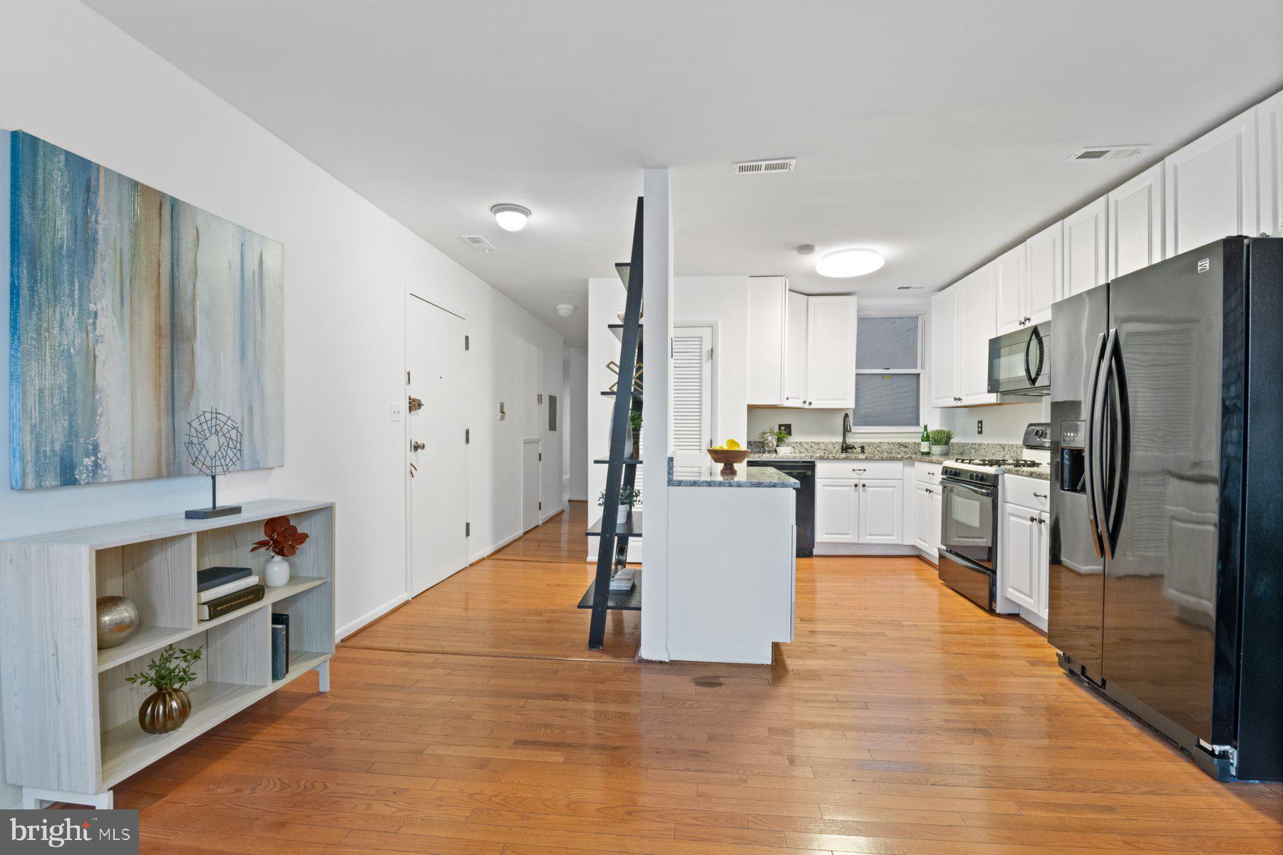36 Q Street Northwest Washington, DC 20001 - Photo 20 of 40 a large open kitchen with stainless steel appliances granite countertop a refrigerator a stove oven and white cabinets