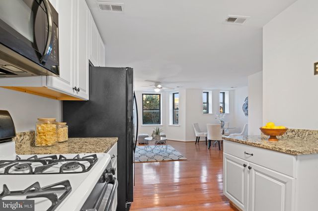 a kitchen with a stove and white cabinets