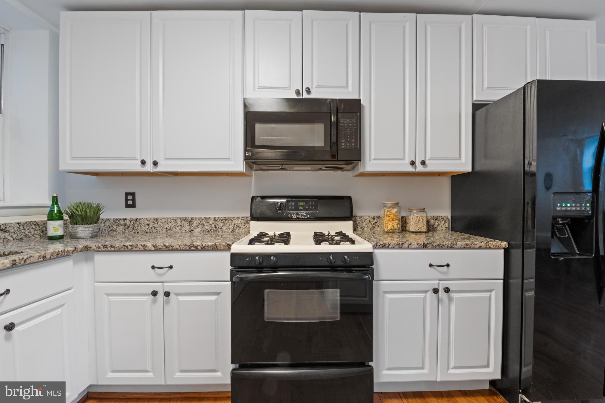 36 Q Street Northwest Washington, DC 20001 - Photo 23 of 40 a kitchen with granite countertop white cabinets and stainless steel appliances