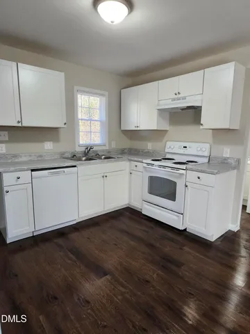 a kitchen with granite countertop a sink and cabinets