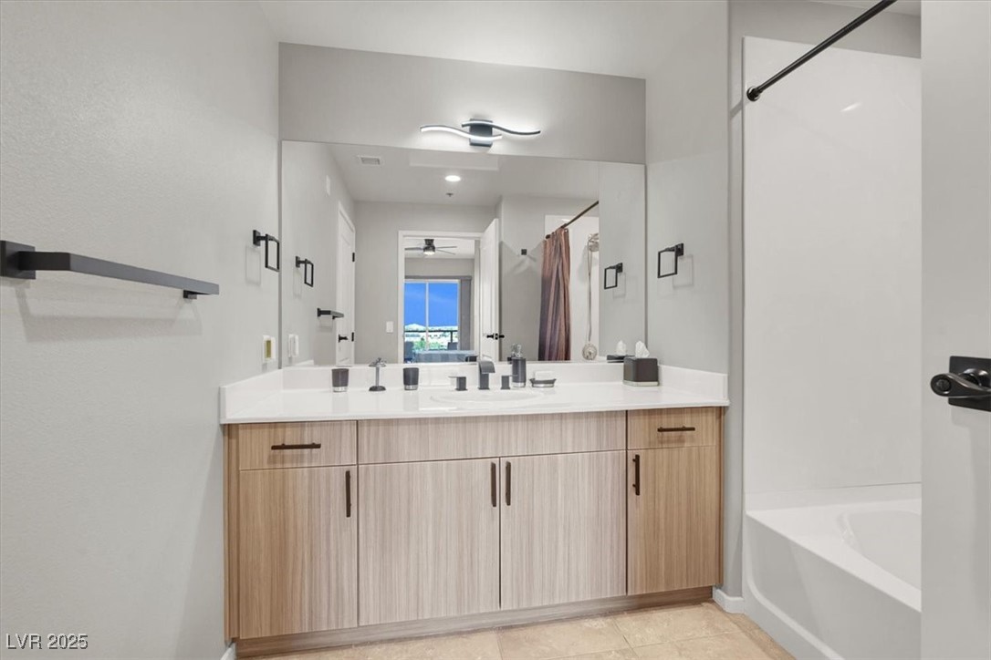 8255 South Las Vegas Boulevard, Unit 722 Las Vegas, NV 89123 - Photo 16 of 40 Bathroom with ceiling fan, vanity, a garden tub, and curtained shower