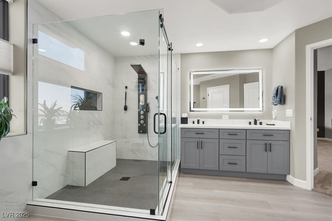 8255 South Las Vegas Boulevard, Unit 722 Las Vegas, NV 89123 - Photo 30 of 40 Full bathroom featuring double vanity, a stall shower, wood finished floors, and recessed lighting