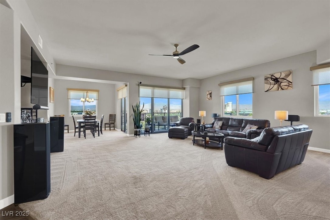 8255 South Las Vegas Boulevard, Unit 722 Las Vegas, NV 89123 - Photo 10 of 40 Living area featuring plenty of natural light, ceiling fan, and carpet floors