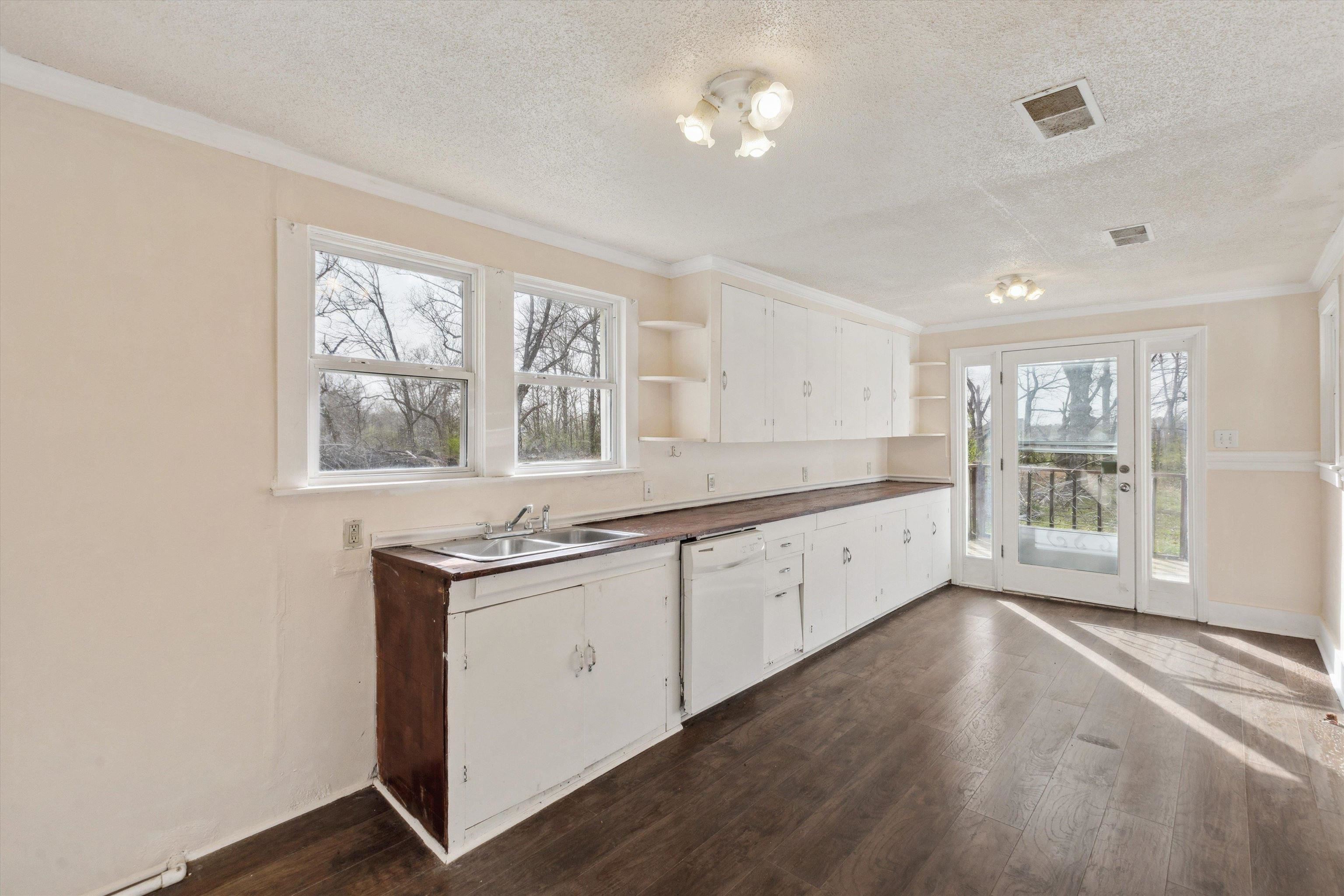 8457 East Kerrville Rosemark Road Millington, TN 38053 - Photo 16 of 32 Kitchen featuring white cabinets, dark countertops, open shelves, dark wood-type flooring, and a textured ceiling
