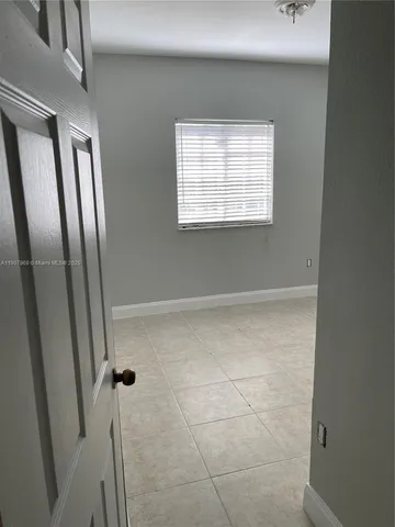 a view of a small space with wooden floor and a window
