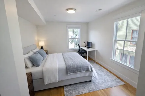 a bedroom with a bed and wooden floor
