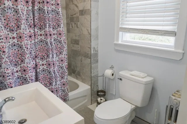 a white toilet sitting next to a bath tub