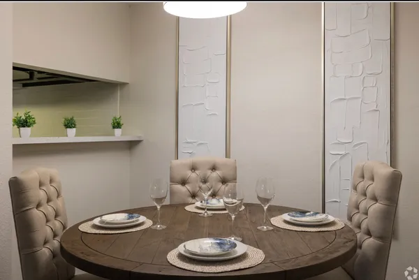 a dining room with furniture and a potted plant