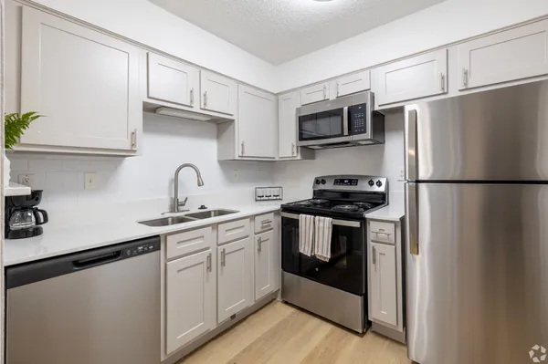 a kitchen with stainless steel appliances granite countertop a refrigerator sink and stove
