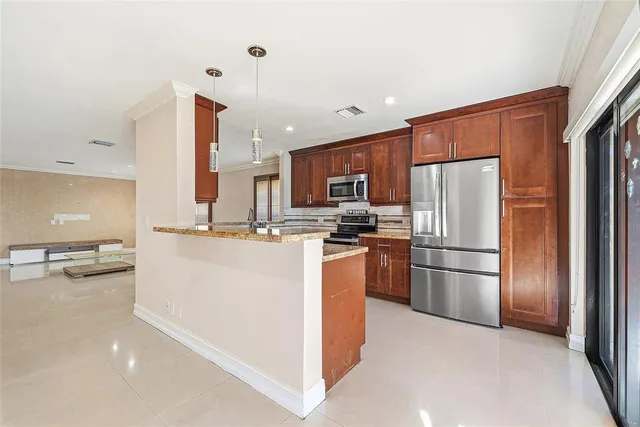 a kitchen with stainless steel appliances granite countertop a refrigerator and a stove top oven