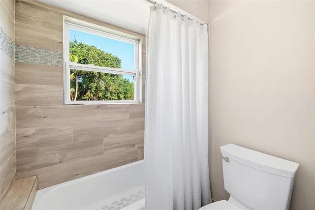 a bathroom with a toilet and a shower