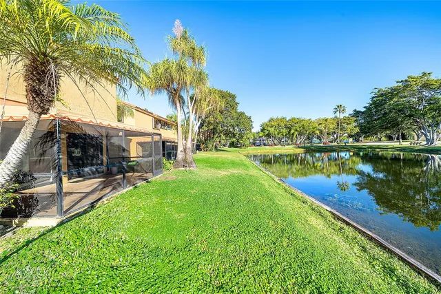 a view of a house with a yard and a fountain