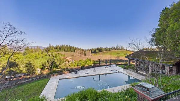 an aerial view of residential houses with outdoor space and ocean view