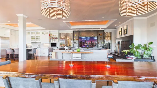 a large kitchen with cabinets chairs and wooden floor