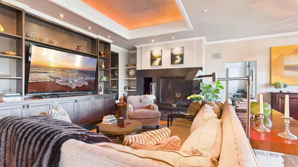 a kitchen with stainless steel appliances kitchen island granite countertop a dining table chairs and a refrigerator