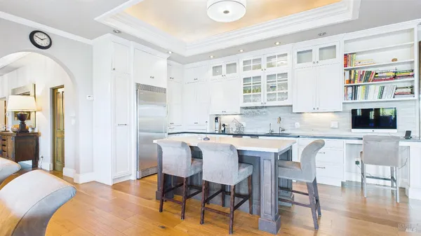 a large kitchen with cabinets a sink a window and chairs