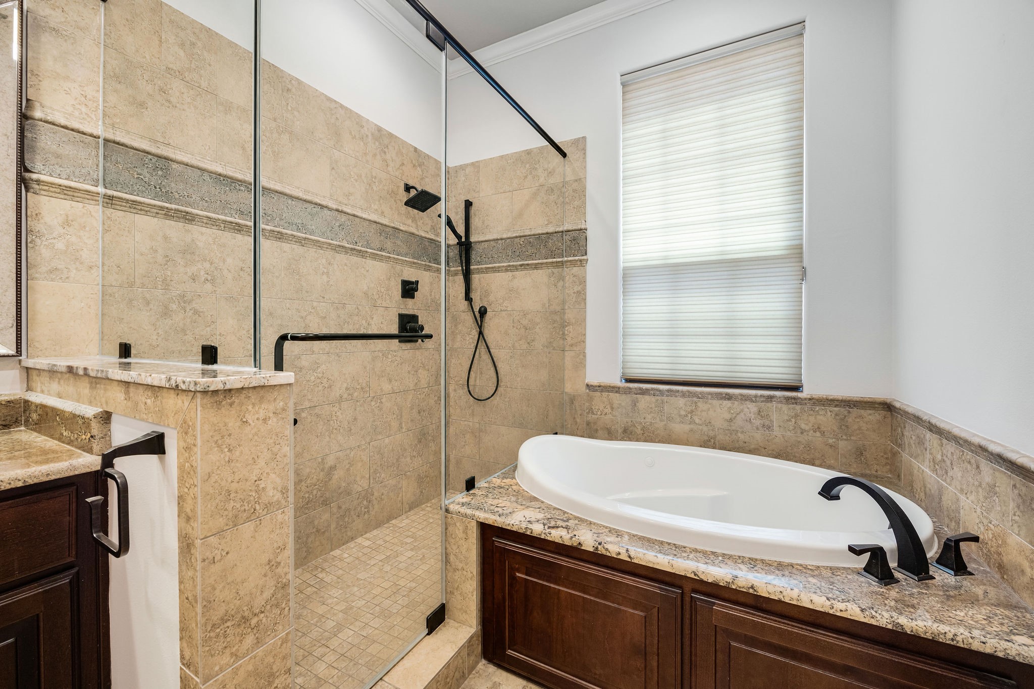 2415 Commonwealth Street Houston, TX 77006 - Photo 17 of 26 Indulge in the luxurious primary bath, where a jetted soaking tub and oversized walk-in shower create the perfect space to relax and recharge.