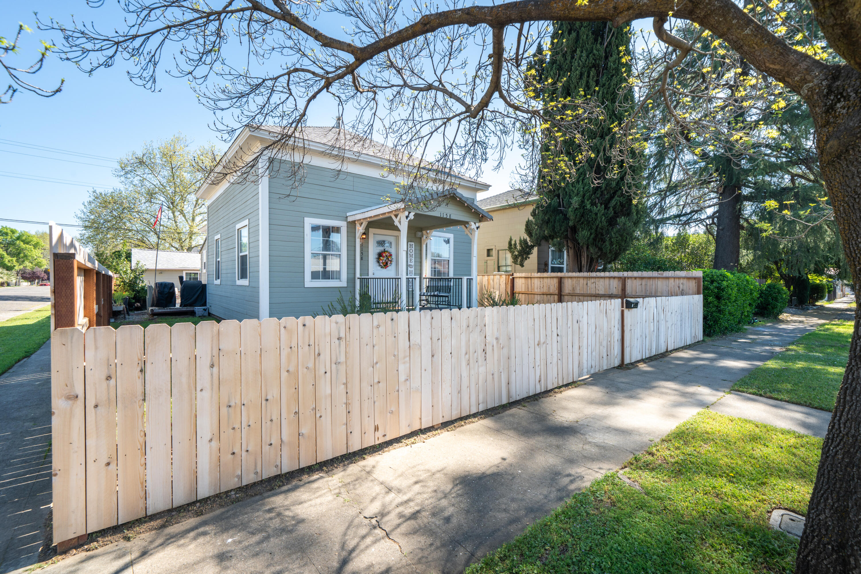 1158 Madison Street Red Bluff, CA 96080 - Photo 30 of 36 a view of backyard with large trees and wooden fence