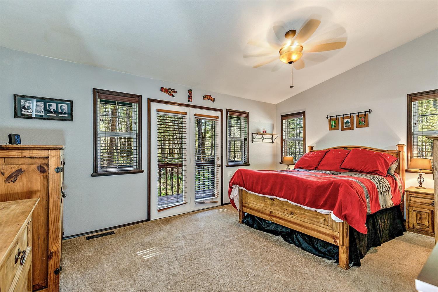 4623 Dick George Road Cave Junction, OR 97523 - Photo 13 of 26 a spacious bedroom with a bed and a chandelier
