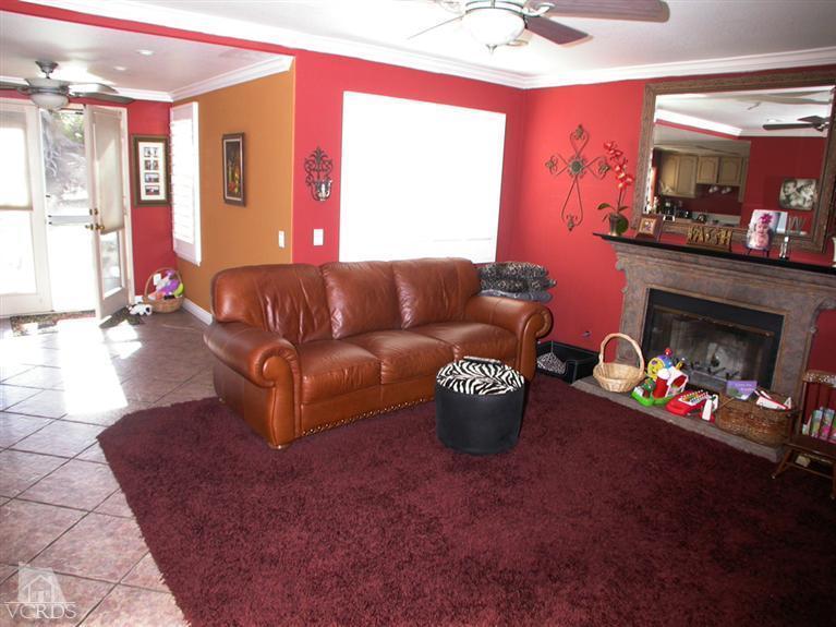321 Fresh Meadows Road Simi Valley, CA 93065 - Photo 10 of 23 a living room with furniture a fireplace and a chandelier
