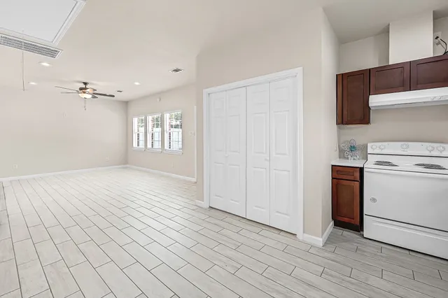 a view of a kitchen with dishwasher and white cabinets with wooden floor